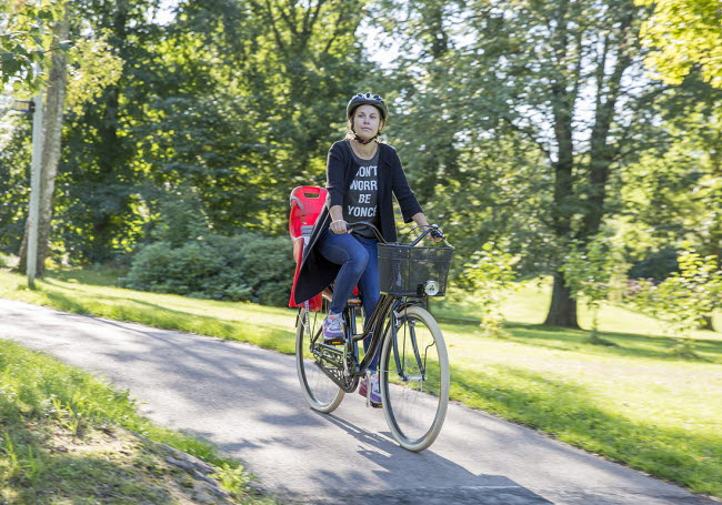 En kvinna cyklar på en cykelväg.