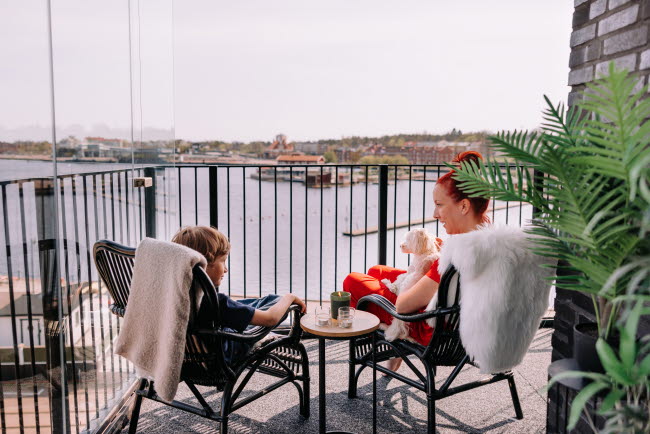 Två människor sitter på en balkong med utsikt över Inre hHamnen