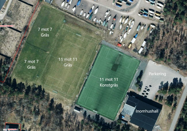 Flygfoto över Ernemar fotbollsanläggningen med uppmärkta plan, inomhulshall och parkering.