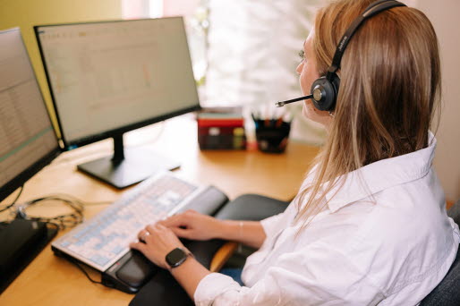 telefonist med headset sitter vid datorn 