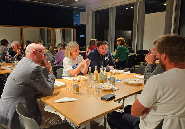 Personer sitter runt ett bord och pratar