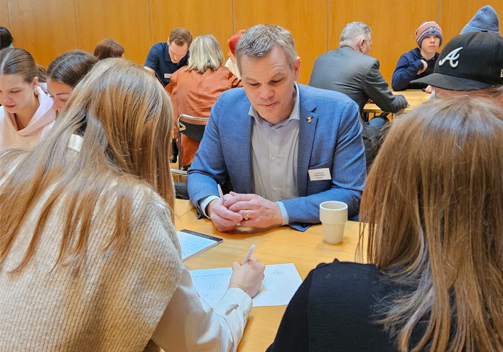Politiker och ungdomar diskuterar i grupper.