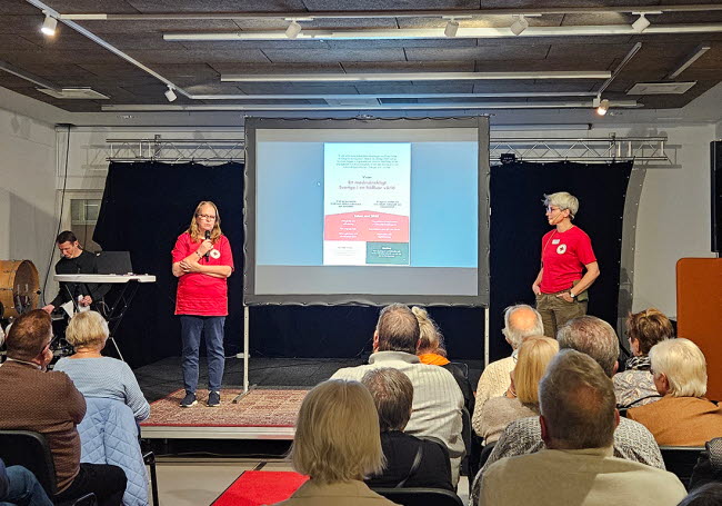 Kristina Danielsson och Ulla Mecke från Röda korset står på scen och föreläser inför publik.