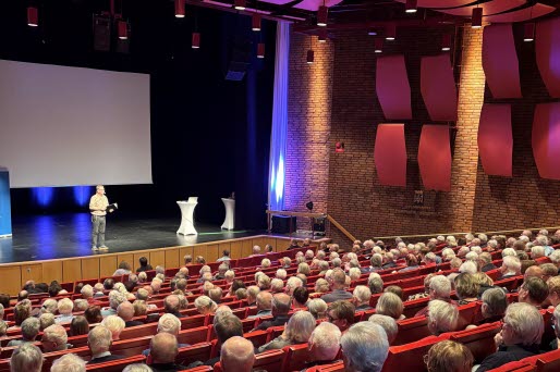 Man på scen framför fullsatt publik