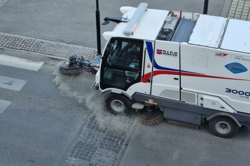 Sopmaskin sopar gatan ren från grus