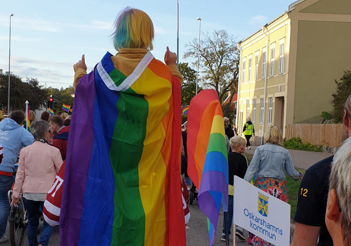 Prideparad med kommunflagga i förgrunden