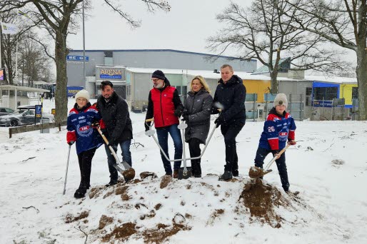 Sex personer tar ett gemensamt spadtag i en grushög, på platsen där den nya träningsishallen ska byggas. 