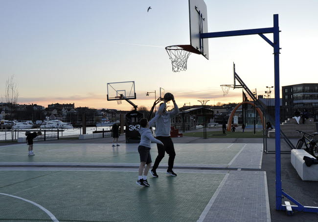 En pojke och hans pappa spelar basket utomhus.