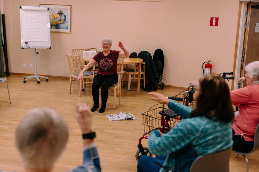 Ett antal äldre personer tränar stolyoga å ett äldreboende.